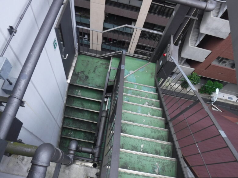 経年劣化の激しい緑色の外部階段